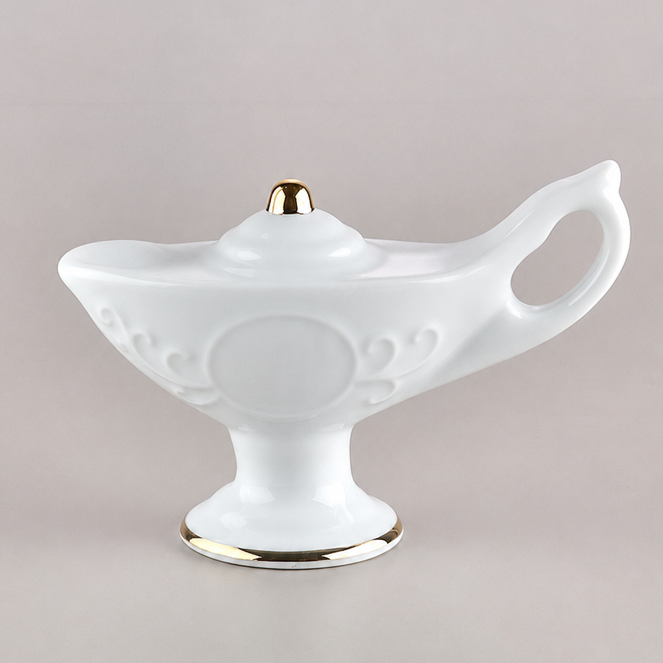 A white porcelain nurses lamp with gold trim and a gold cap, set against a solid light gray background.